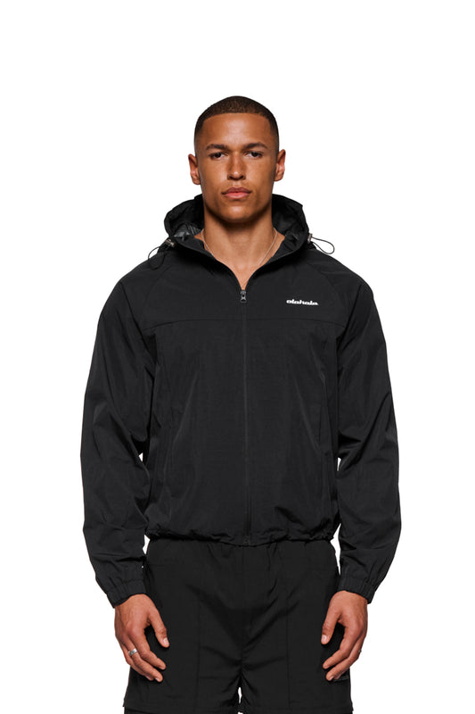 Mann trägt den Windbreaker Black mit verstellbarer Kapuze und Reißverschlusstaschen, ideal für Wind- und Regenschutz. Unisex-Design von OLAKALA.