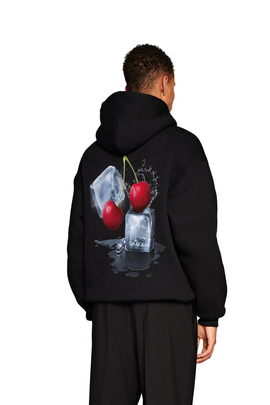 Person trägt schwarzen Neighbour's Cherries Hoodie mit Grafikdesign auf dem Rücken und gesticktem OLAKALA-Logo auf der Brust, reguläre Passform, unisex.