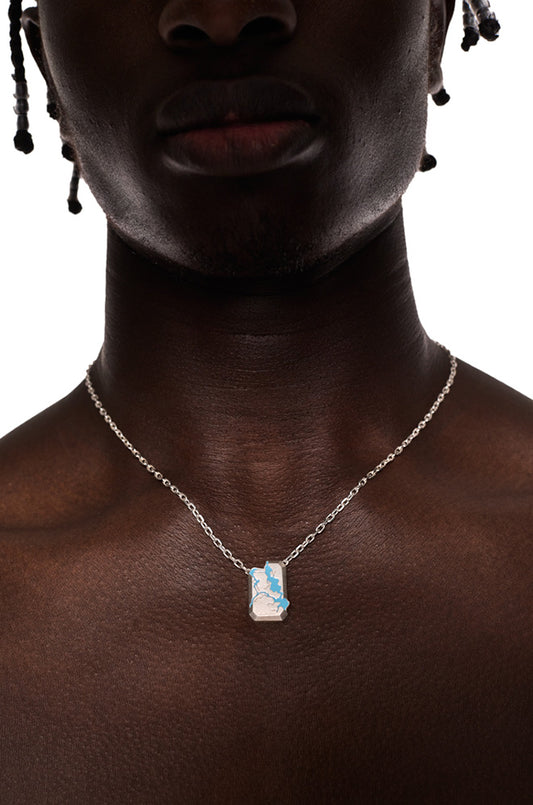 Person trägt die Synergy Gem Necklace mit einem Anhänger im zerstörten Look und blauen Elementen, an einer längenverstellbaren Kette von 49 cm.