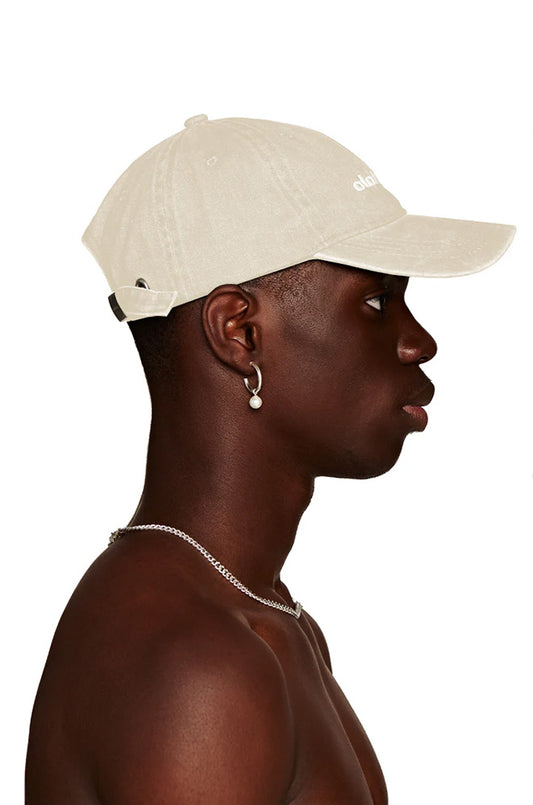 Mann trägt die CC Essential Cap Beige mit gesticktem OLAKALA-Logo; verstellbar mit Metallclip, Einheitsgröße, modisches Accessoire.