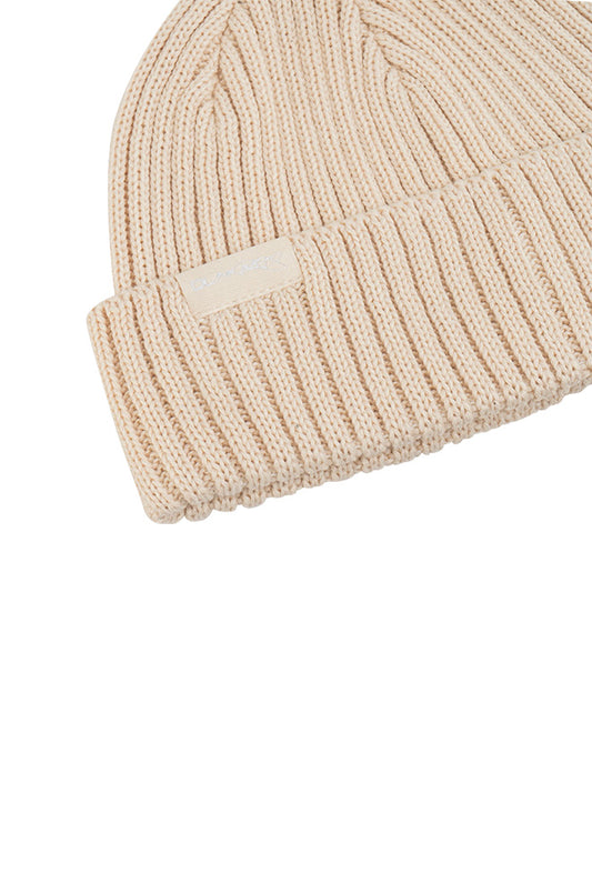 Nahaufnahme des Alien Intel Beanie Beige im gerippten Fisherman Style mit gewebtem OLAKALA-Label am Umschlag, Einheitsgröße.