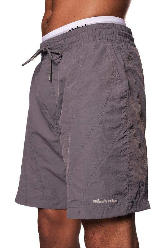 Naxos Swim Shorts Gray mit Kordelzug, französischen Taschen und reflektierendem OLAKALA-Logo auf dem linken Bein, reguläre Passform.